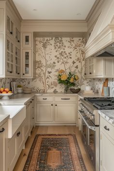 a kitchen with white cabinets and floral wallpaper