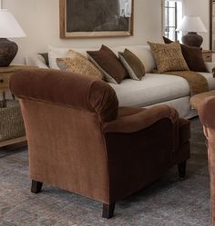 a living room filled with lots of furniture next to a wall mounted painting on the wall