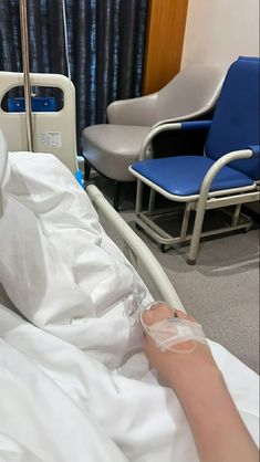 a person in a hospital bed with an oxygen tube wrapped around their arm and hand