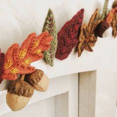 an arrangement of autumn leaves and acorns hanging on a fireplace mantel or mantle