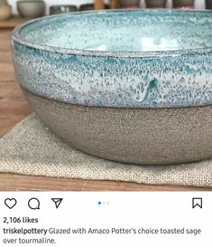 a blue and white bowl sitting on top of a wooden table next to a cloth