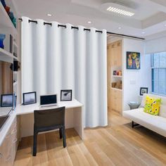 a living room filled with furniture and white curtains