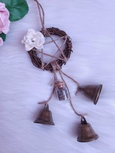 three bells hanging from a rope with flowers