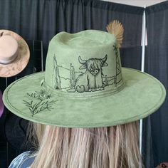 Y’all, this isn’t just hat art—it’s a whole mood. 🤠🌿 Hand-burned with love, this green suede fedora brings the charm of rustic ranch vibes to life. That Highland cow? Total scene-stealer. Did you know we have never been able to keep a Highland cow on the shelves long after it's burned? They always sell as soon as we put them out! And we've burned quite a few!🐂🔥 Who’s ready to make a statement with a little wild west flair? #HandBurnedHats #WesternChic #SouthwestStyle #HatTattCo Ranch Vibes, Burnt Hats, Cowboy Hat Styles, Hat Burning, Scene Stealer, Hat Art, Felt Cowboy Hats, Make To Sell, Hat Styles