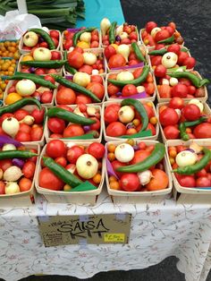 many different types of fruits and vegetables are on display at the market table for sale