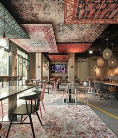 a restaurant with tables, chairs and rugs on the floor