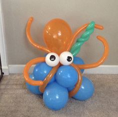 an orange and blue balloon octopus sitting on the floor