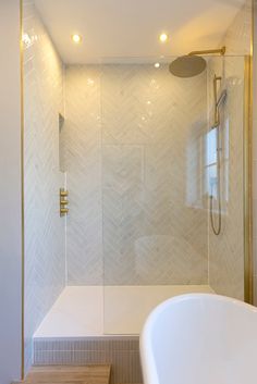 a bathroom with a walk in shower next to a white bathtub and wooden steps