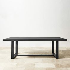 a black table sitting on top of a tiled floor next to a white brick wall