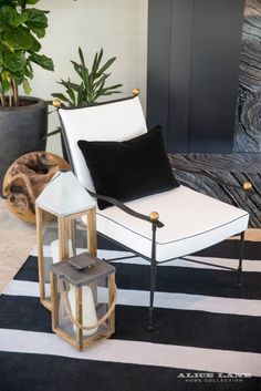 a black and white chair sitting on top of a rug next to a potted plant