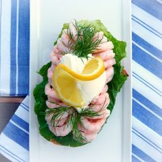 a white plate topped with shrimp and lemon slices