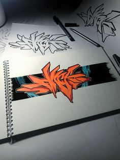 a notebook with some graffiti on it next to a pen and paper clippings