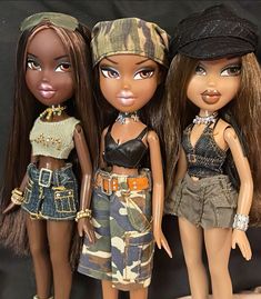 three dolls standing next to each other wearing clothes and hats, one with her eyes closed