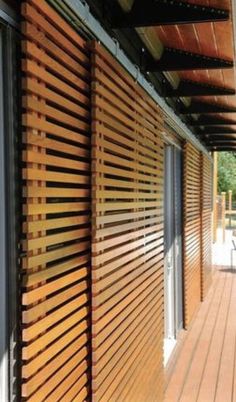 the outside of a building with wooden slats on it's sides and sliding glass doors