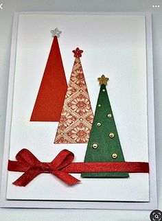 three christmas trees made out of paper on a white card with red ribbon around the edges