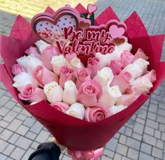 a person holding a bouquet of roses with the words be my valentine written on it