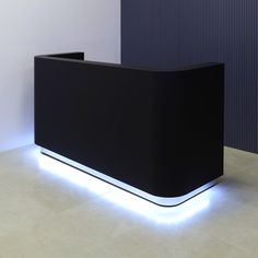 a black reception table with white lights on the side and a blue wall behind it