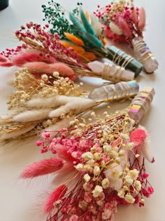 flowers and feathers are arranged on a table