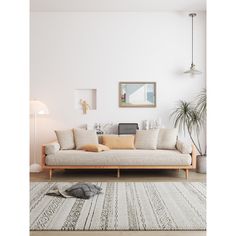 a living room with a couch, rug and pictures hanging on the wall above it