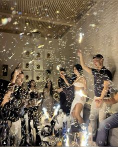 a group of people standing next to each other in front of bubbles and confetti