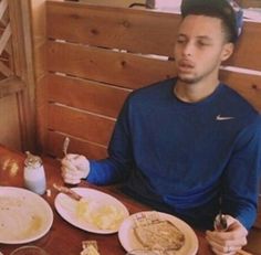 a man sitting at a table with plates of food