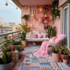 a balcony decorated with potted plants and hanging decorations on the wall, along with a couch