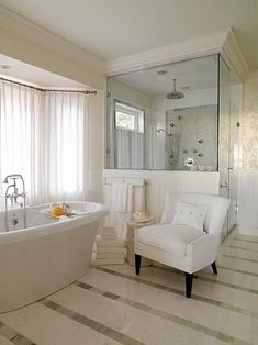 a bath room with a tub a chair and a window