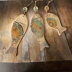 two wooden fish ornaments hanging on a table