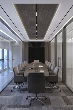 an empty conference room with chairs and a long table in the center, along with glass walls