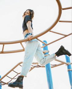 a woman is walking on the top of a playground structure with her feet in the air