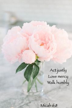 a pink flower in a glass vase on a marble table with water droplets around it