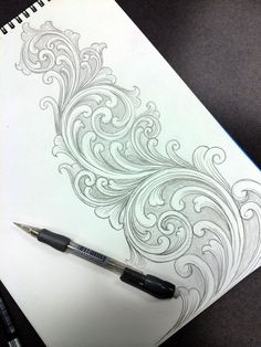 a pen is sitting on top of a drawing book with an intricate design in it