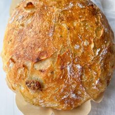 a baked bread sitting on top of a wooden cutting board