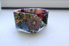 a close up of a colorful bracelet on a white table with a window in the background