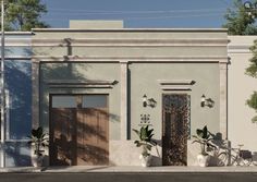 an old style building with two doors and three bicycles parked in front of the door