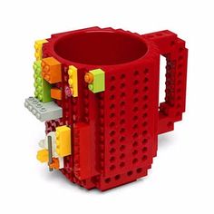 a red coffee mug with legos on the inside and outside, in front of a white background