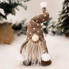 a knitted gnome figurine sitting in the snow