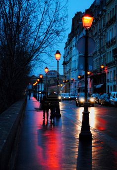 people are walking down the street at night