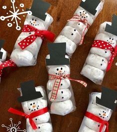 snowmen made out of toilet paper wrapped in red ribbon and black top hats with bows