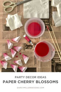 party decor ideas paper cherry blossoms with scissors and other crafting supplies to make them look like they are floating in the water