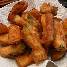 some fried food is on a white plate and ready to be eaten with chopsticks