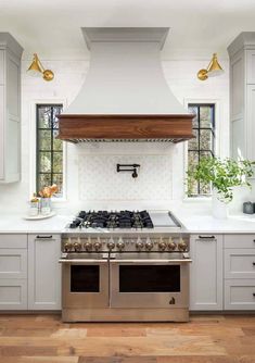 a stove top oven sitting inside of a kitchen next to white cabinets and counter tops