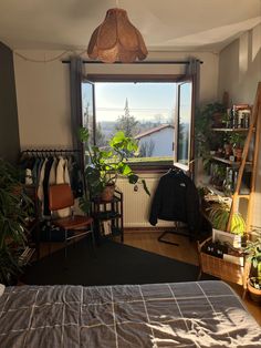 a bedroom with a bed, chair and window looking out onto the city below it