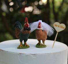 two chickens are standing on top of a cake with a sign that says mr and mrs