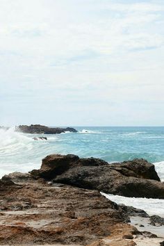 a person standing on rocks near the ocean