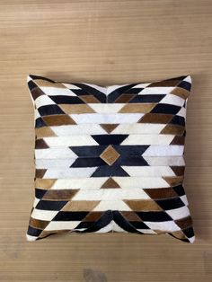 a brown and white pillow on top of a wooden floor