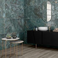 a bathroom with green marble walls and flooring, two sinks and a mirror on the wall