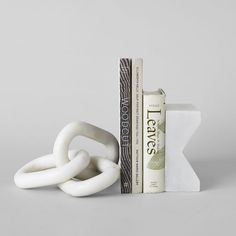 a bookend with two white rings sitting on top of each other next to a stack of books