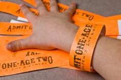 an orange wristband with words on it is being held by someone's hand