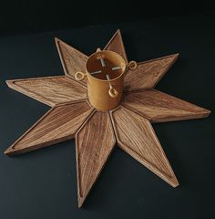 a wooden star shaped clock with a cup on it's side and cross in the middle